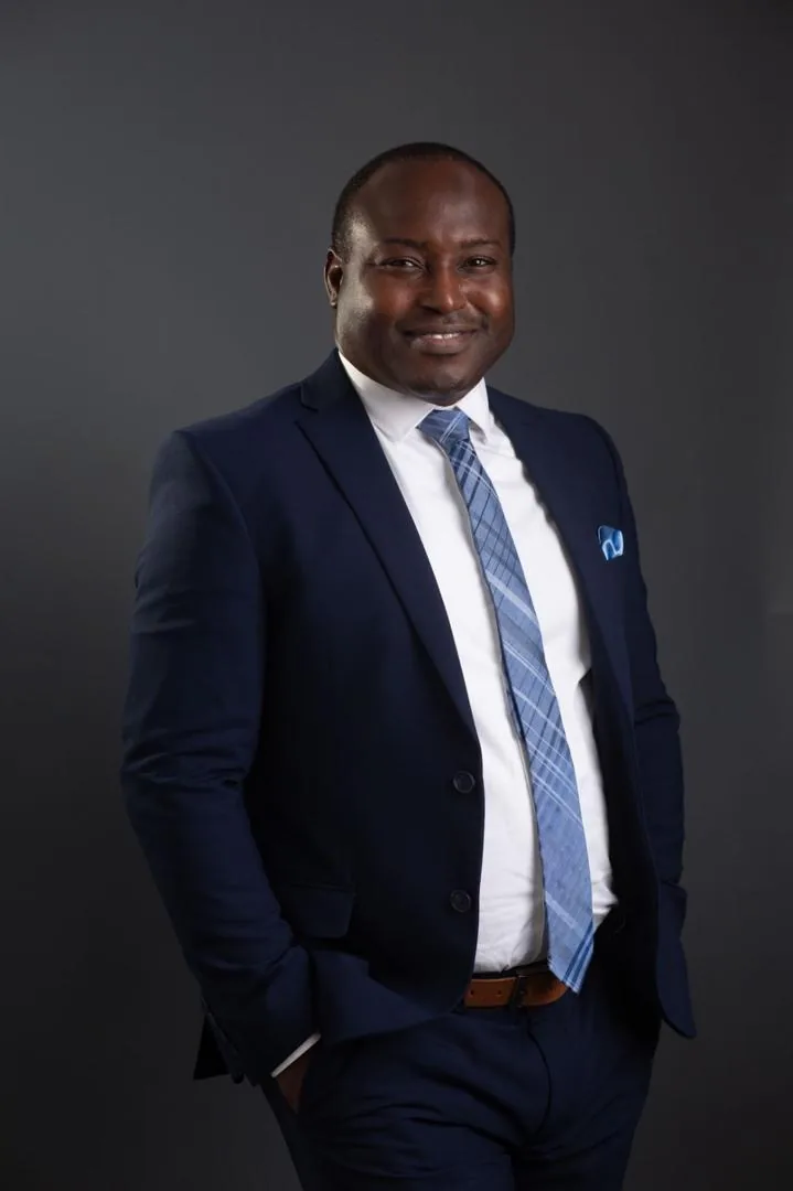 Dr. Basheer Oshodi, standing portrait in a navy suit